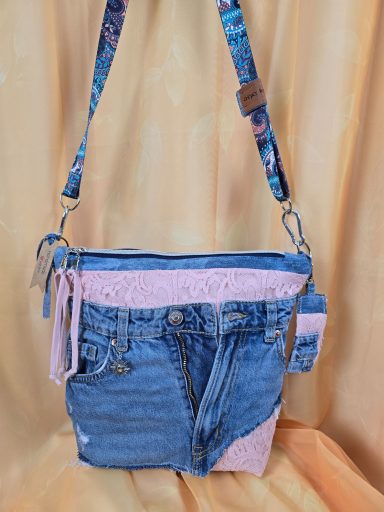 Tasche aus Denim mit pinken und blauen Akzenten und verstellbarem Tragegurt.