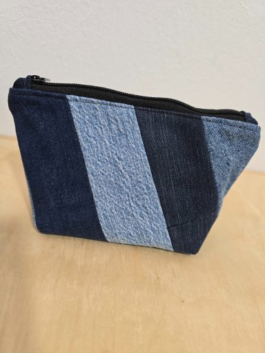 Eine kleine Kosmetiktasche aus blauen, abwechselnd genähten Jeansstoffen.