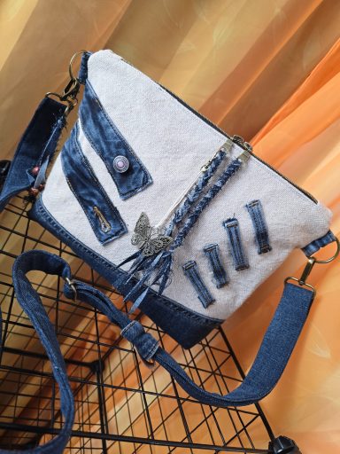 Tasche aus Denim mit verschiedenen Texturen und dekorativen Elementen.