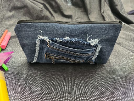 Denimtäschchen mit einem abgerissenen Futteral und Reißverschluss vorne.