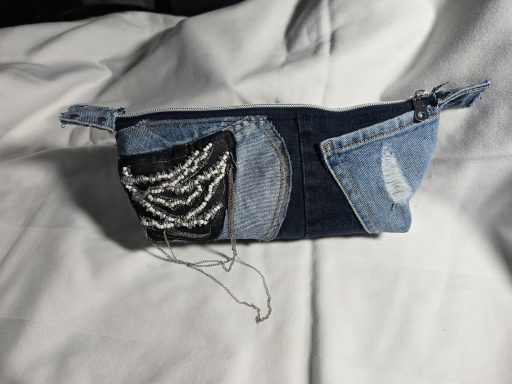 Blaues Täschchen aus Jeansstoff mit verschiedenen Texturen und Stickereien.