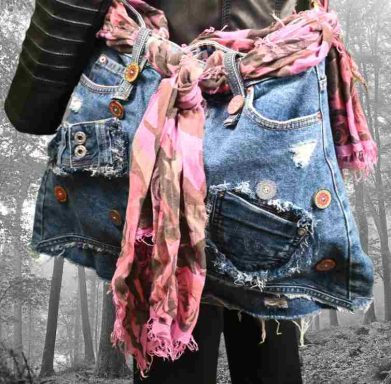 Bunte Jeanstasche mit Aufnähern und bunten Knöpfen, umwickelt mit einem rosa Schal.