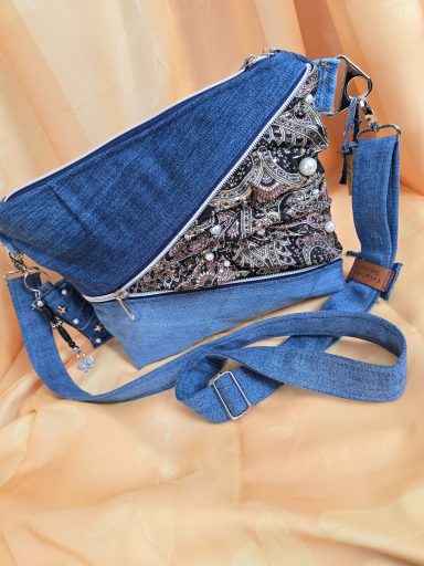 Tasche aus verschiedenen Denimstoffen mit floralem Muster und verstellbarem Schulterriemen.