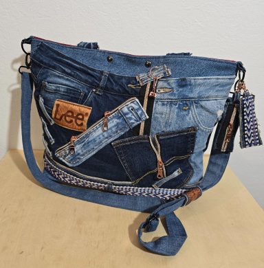 Tasche aus Jeansstoff mit verschiedenen Denim-Elementen und auffälligen Anhängern.