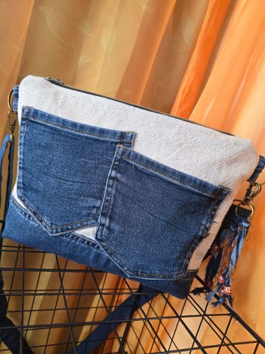 Tasche aus Jeansstoff mit unterschiedlichen Denim-Farben und einem fransigen Anhänger.