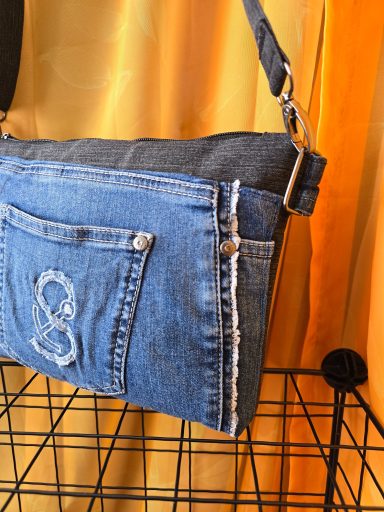 Tasche aus Denim mit einer aufgestickten Zahl 8 und einem kurzen Schulterriemen.