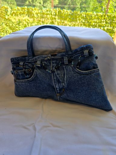 Tasche aus Jeansstoff mit Tragegriffen und einer Tasche vorne.