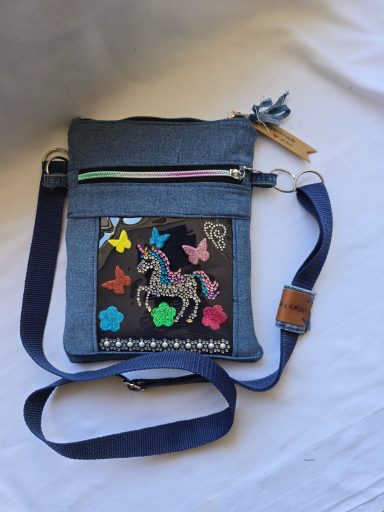 Schicke Umhängetasche mit bunten Aufnähern von Einhorn und Schmetterlingen.