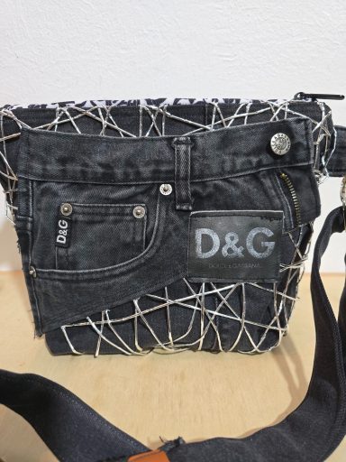 Schwarze Tasche mit Jeans-Design und weißen Fadenmustern, D&G-Logo sichtbar.