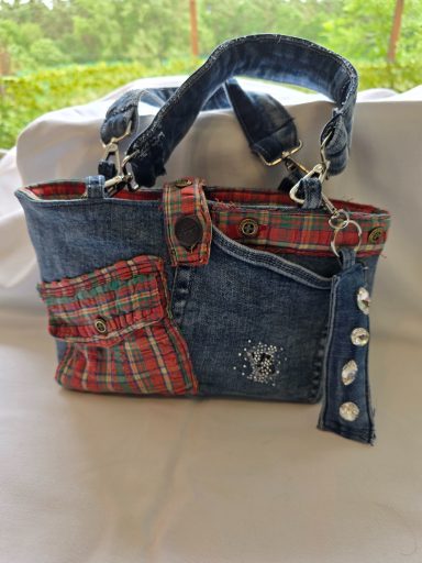 Handtasche aus Denim mit Karomuster und dekorativen Knöpfen.