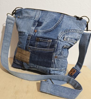 Tasche aus verschiedenen Jeansstoffen mit langen Trägern und Reißverschluss.