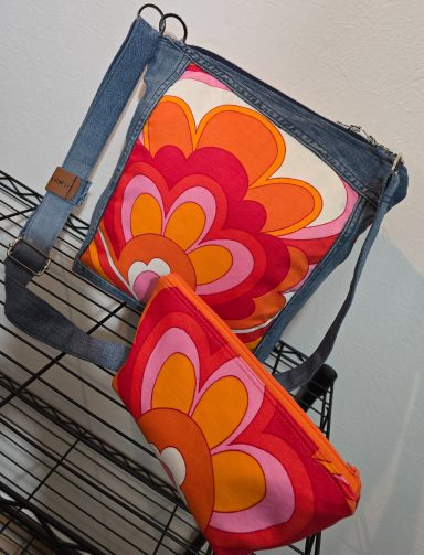 Bunte Schultertasche mit Blumenmuster und passendem Mini-Beutel.