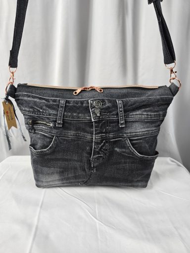 Schwarze Umhängetasche im Jeanslook mit Taschen und Reißverschluss.