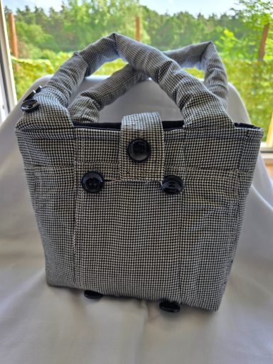 Grau gestreifte Handtasche mit zwei Griffen und Knopfverschluss.