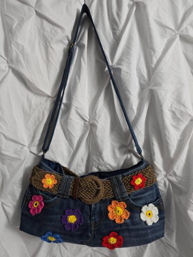 Kleine Handtasche aus Jeans mit bunten Blumenornamenten.