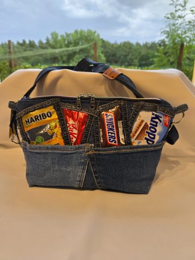 Eine Tragetasche aus Jeans mit Snacks und Süßigkeiten darin.