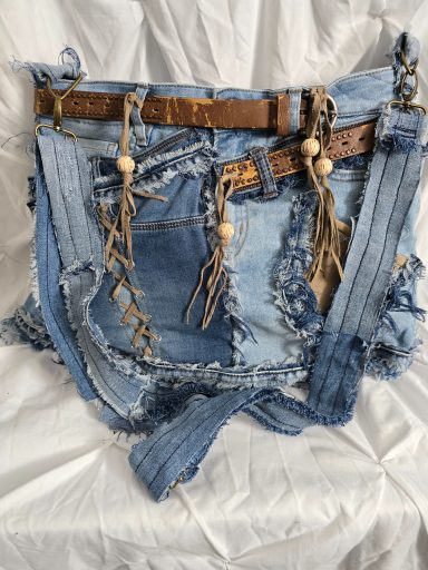 Jeans-Tasche mit Fransen und Holzperlen, in verschiedenen Blautönen und zerrissener Optik.