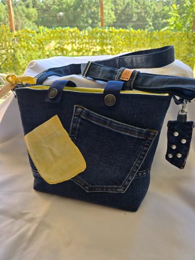 Tasche aus Jeansstoff mit gelbem Detail und kleiner Fronttasche.