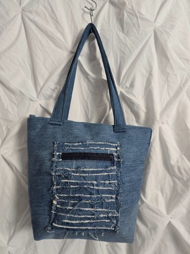 Denim Tasche mit einem Reißverschlussfach und langen Tragegriffen.