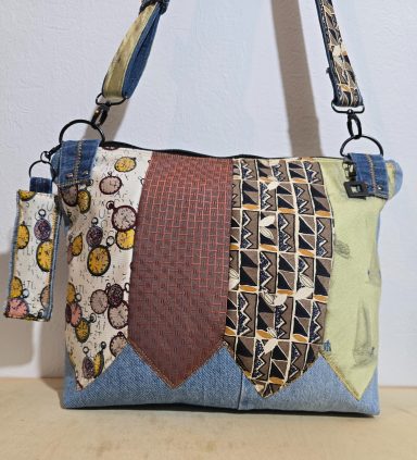 Bunte Umhängetasche aus Stoff und Jeans mit gemusterten Paneelen und einem langen Schultergurt.